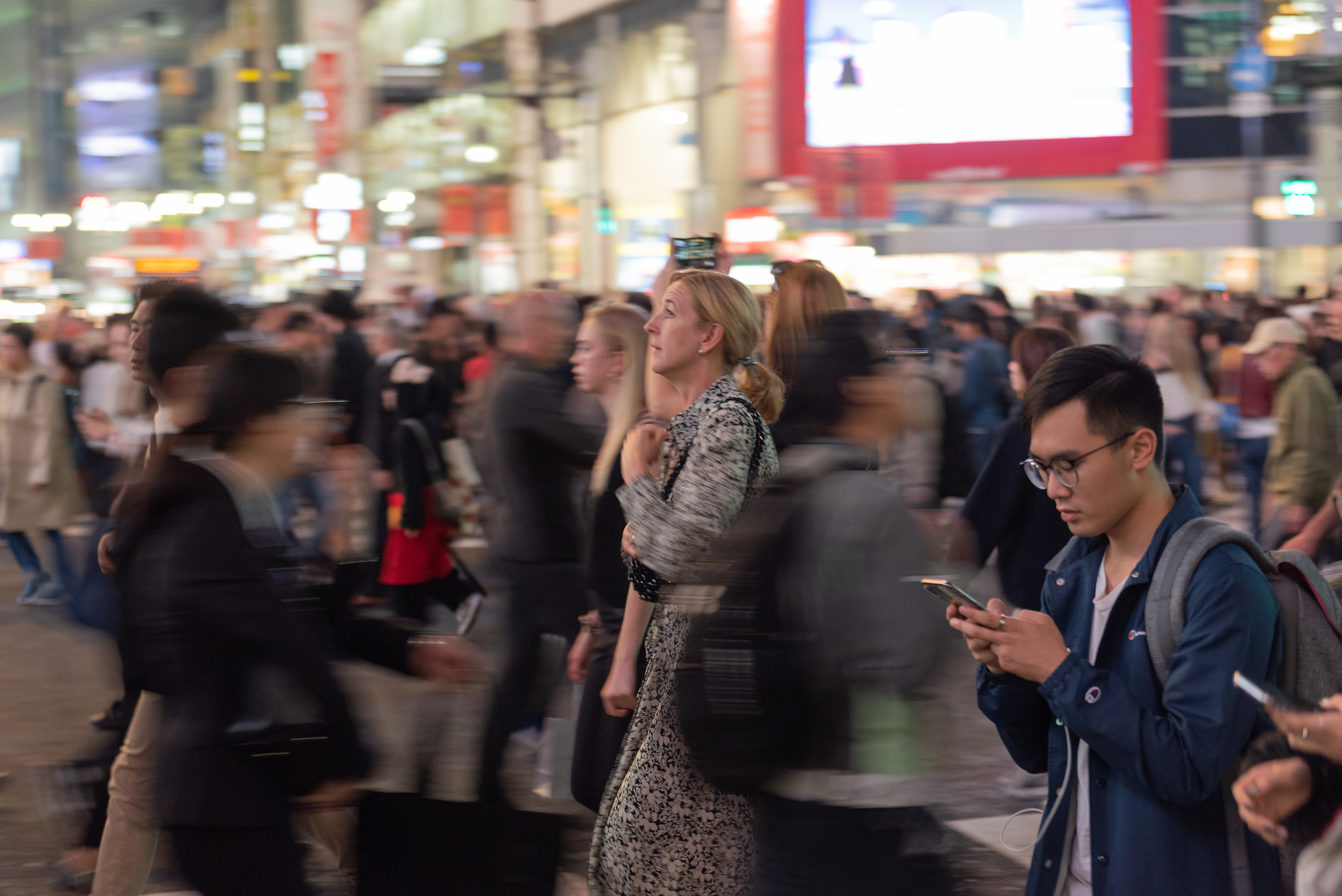 Crowd of people walking around and looking at their mobile devices